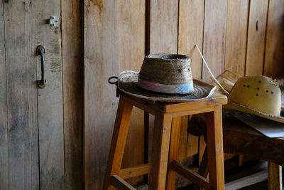 Close-up of old wooden table against wall