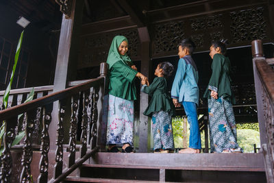 People standing by railing against building