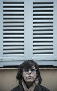 Close-up portrait of woman wearing eyeglasses against window