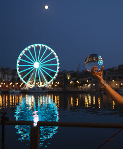 Illuminated ferris wheel against sky at night