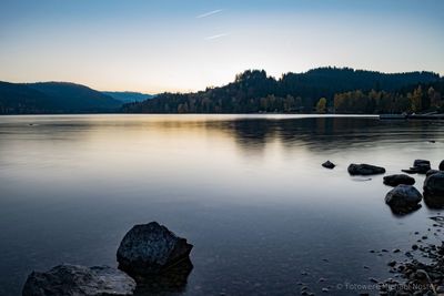 Scenic view of lake against sky at sunset