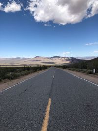 Road leading towards mountain against sky