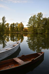 Boat moored in lake against sky