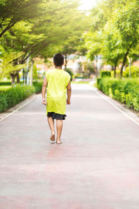 Rear view of woman walking on road