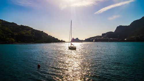 Sailboats in sea against sky