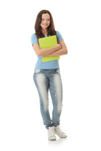 Portrait of smiling young woman standing against white background