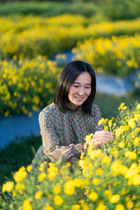 Young woman with yellow flower in field