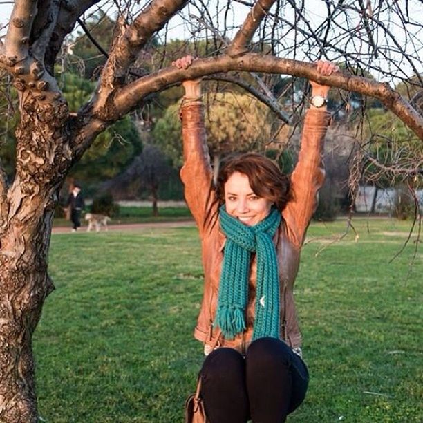 tree, lifestyles, person, young adult, grass, leisure activity, casual clothing, tree trunk, looking at camera, young women, front view, standing, park - man made space, portrait, smiling, three quarter length, grassy, happiness