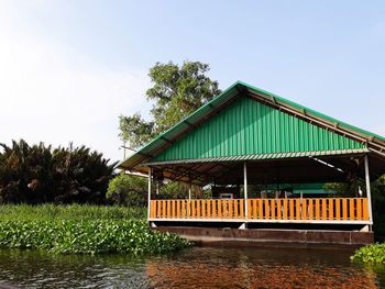 View of cottage by lake against clear sky