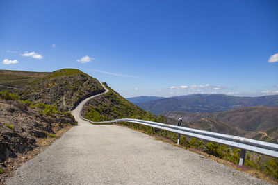 Road leading towards mountains against sky