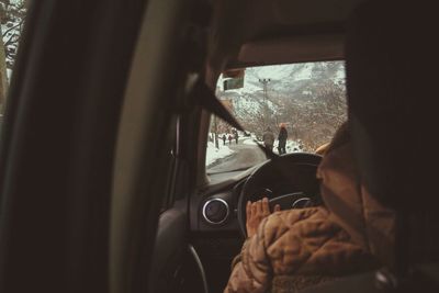 Cropped image of person driving car