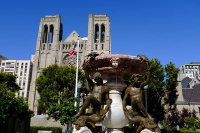 Low angle view of fountain against building in city