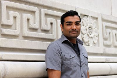 Portrait of young man standing against steps