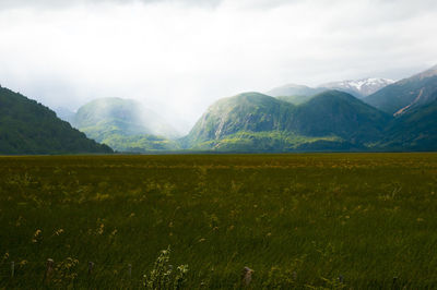 Scenic view of land and mountains against sky