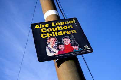 Low angle view of information sign against blue sky