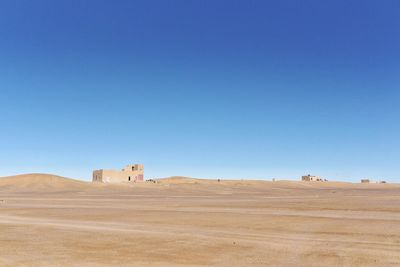 Scenic view of desert against clear blue sky