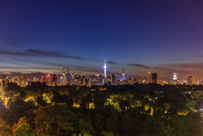 Illuminated city against sky at night