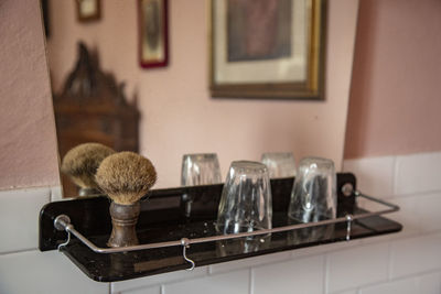 Close-up of bathroom mirror with glasees and shaving brush 