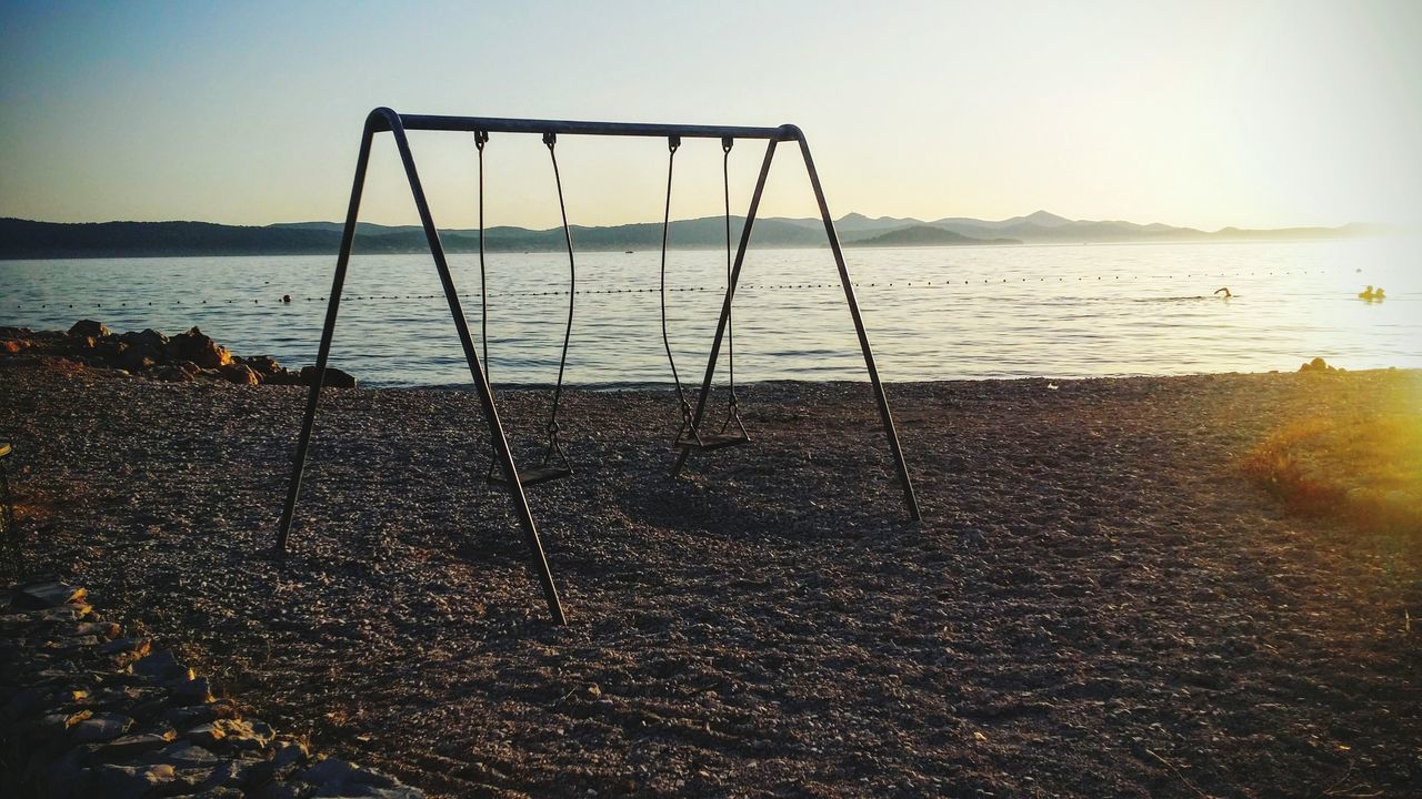 sea, beach, nature, horizon over water, sand, sky, water, sunlight, tranquil scene, tranquility, outdoors, swing, no people, day, beauty in nature