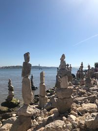 Stack of rocks on beach against clear blue sky