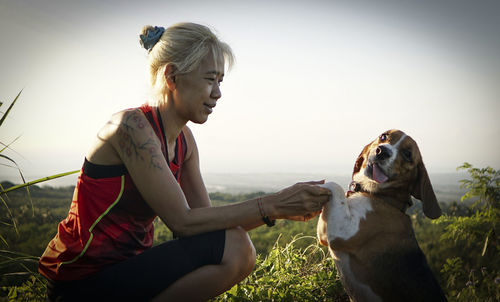 A woman shaking hand with the dog.