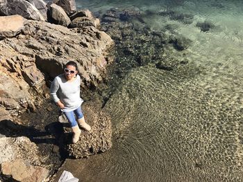 High angle view of young woman on rock