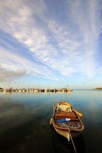 Sailboats moored in sea against sky