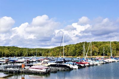 Boats moored at harbor against sky