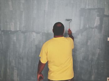 Rear view of man painting wall