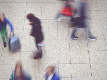 Low section of people walking on tiled floor