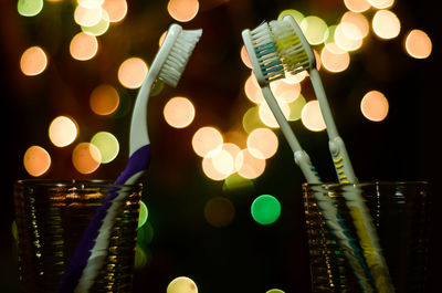 Close-up of toothbrush against illuminated lights