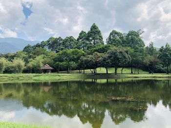 Scenic view of lake by trees against sky