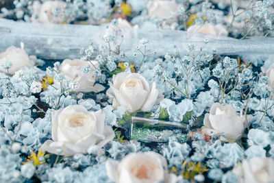 Roses, gypsophila, limonium, glass bottles. flower arrangement of white and blue flowers.