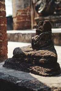 Close-up of old stack of firewood by building