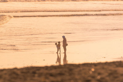 Rear view full length of man walking at beach