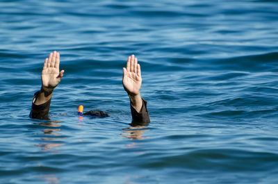 Cropped hands of woman in sea