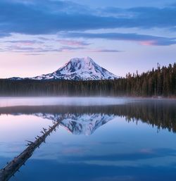 Scenic view of lake by snowcapped mountains against sky