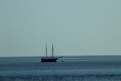 Sailboat on sea against clear sky