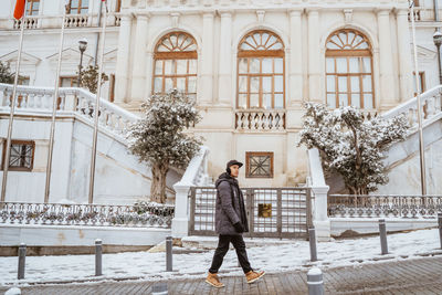 Portrait of young woman standing in front of building