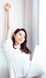 Young asian woman stretching her arms after using laptop.