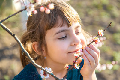 Close-up of girl smelling flowers