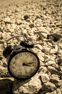 Close-up of alarm clock on stones