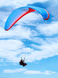 Low angle view of person paragliding against sky