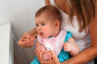 Mother feeding cute baby girl vegetable puree from a spoon. healthy eating nutrition for little kids
