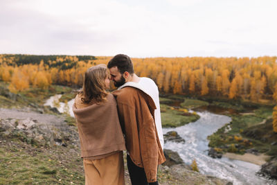 Happy people in love are travel hike in nature in the autumn forest. romantic trip to countryside