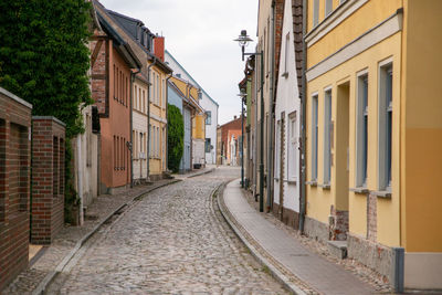 Empty alley amidst buildings in city