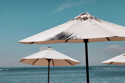 Umbrellas on beach by sea against sky