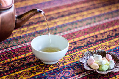 Close-up of tea pouring in cup on table