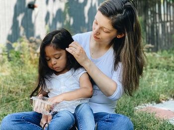 Mother and daughter sitting outdoors