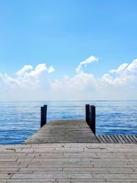 Pier over sea against blue sky